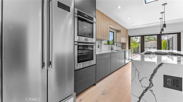 a kitchen with stainless steel appliances granite countertop a refrigerator and a stove top oven