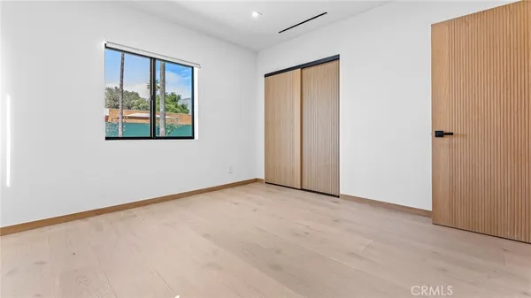 an empty room with windows and closet