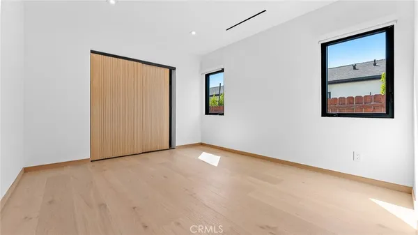 an empty room with windows and closet
