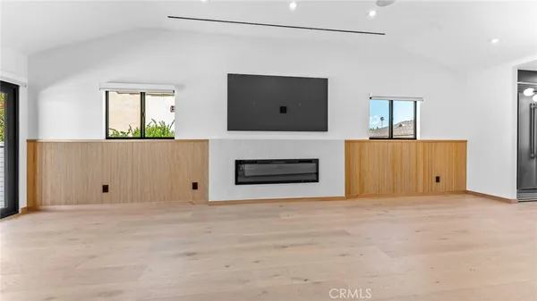 a view of an empty room with a fireplace and a window