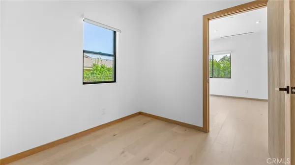 a view of a big room with wooden floor and windows