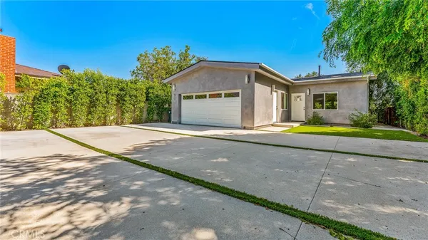 a view of a house with backyard and garden