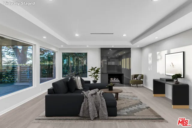 a living room with furniture large window and fireplace