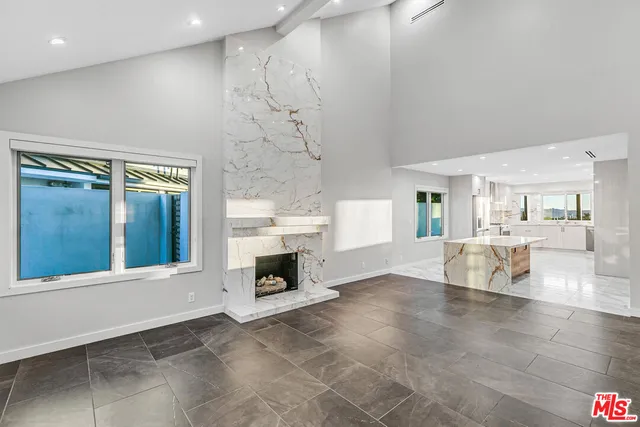 a view of an empty room with a fireplace and window