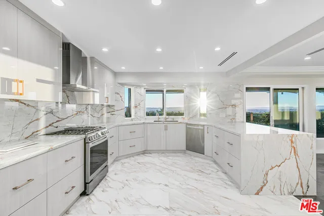 a kitchen with stainless steel appliances kitchen island granite countertop a refrigerator and a sink
