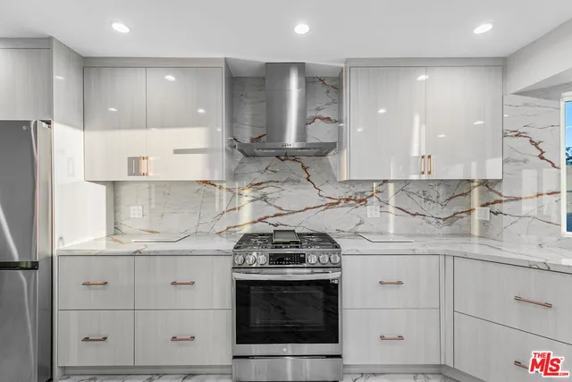 a large white kitchen with a sink and dishwasher with wooden floor