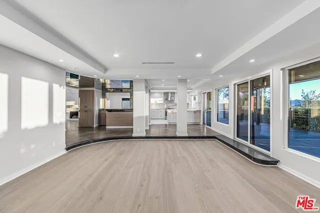 a view of a hallway with wooden floor and glass door