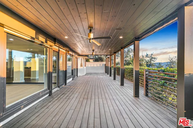 a view of an empty room with wooden floor and windows