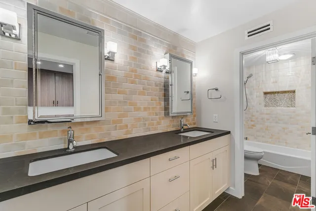 a bathroom with a sink a toilet and a large mirror