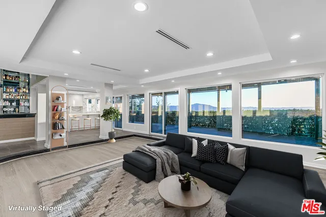 a living room with furniture large window and fireplace