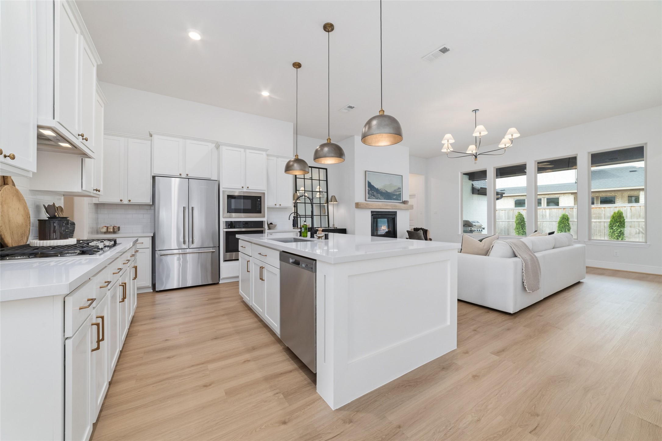 15208 Tree Swallow Court Magnolia, TX 77354 - Photo 5 of 50 a large kitchen with stainless steel appliances kitchen island granite countertop a stove a sink a refrigerator and a wooden floor
