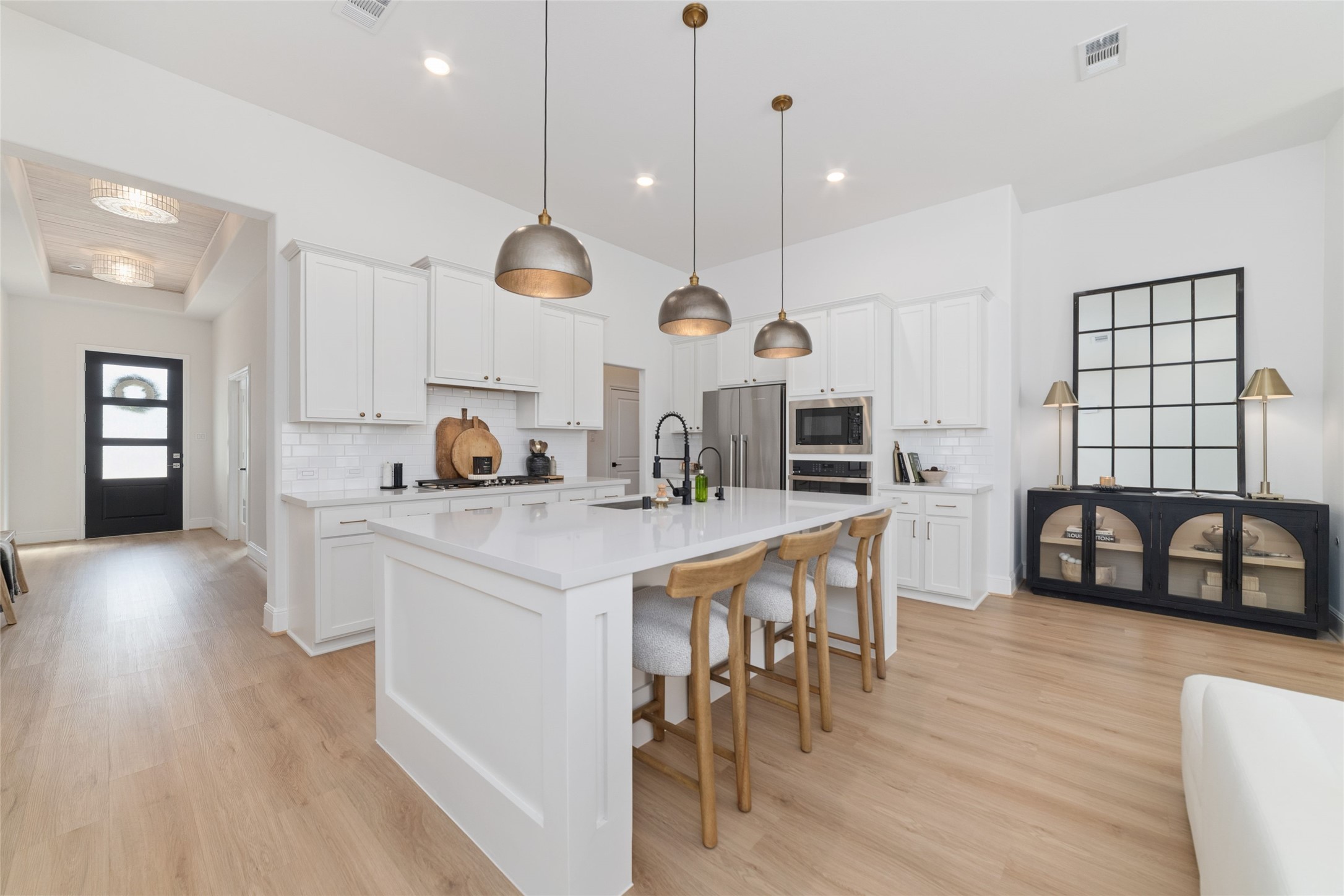 15208 Tree Swallow Court Magnolia, TX 77354 - Photo 7 of 50 a kitchen with stainless steel appliances kitchen island granite countertop a stove a sink a oven and a dining table with wooden floor