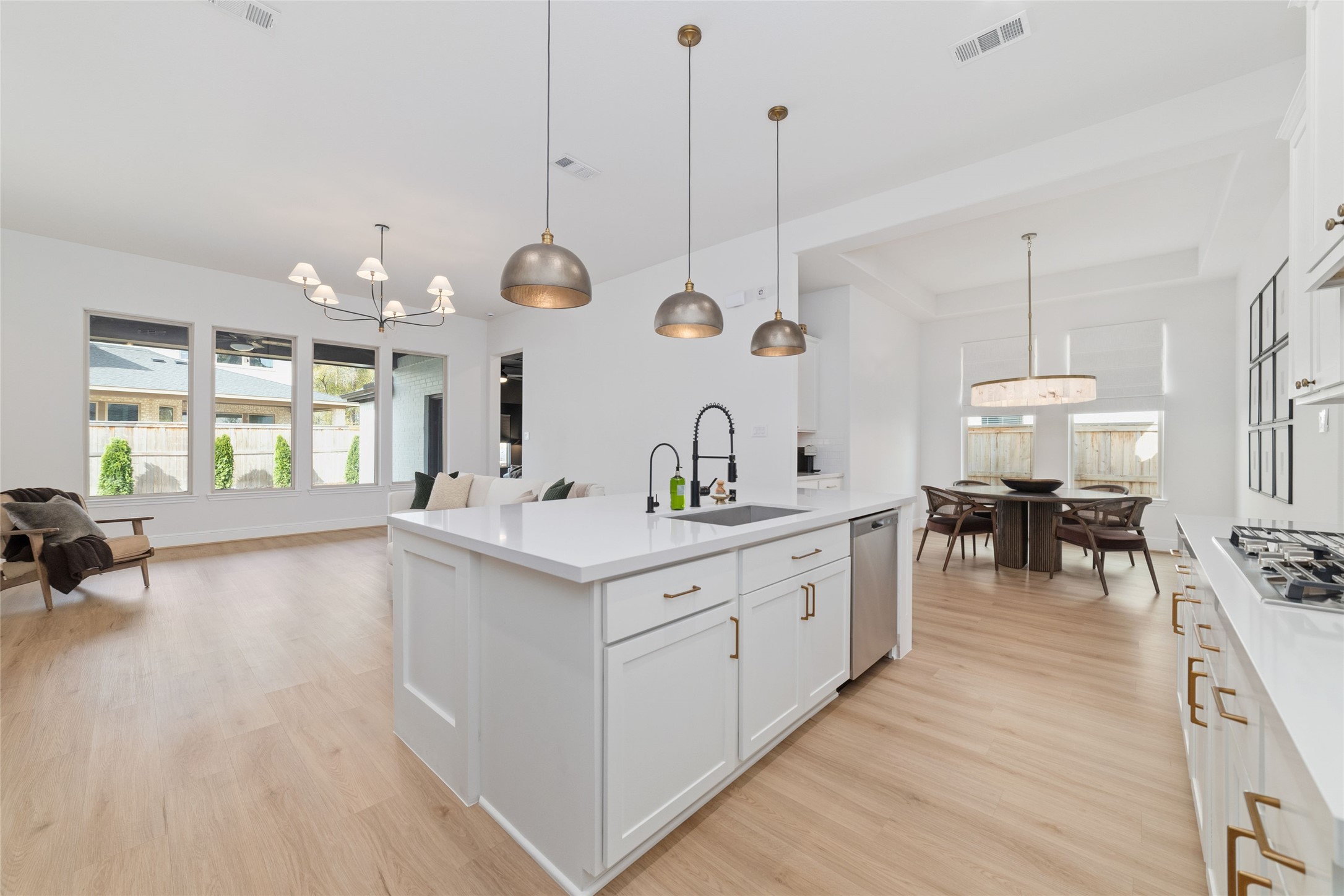 15208 Tree Swallow Court Magnolia, TX 77354 - Photo 9 of 50 a large kitchen with kitchen island a stove a sink a dining table and chairs with wooden floor