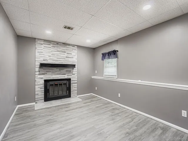 a view of empty room with wooden floor and fireplace
