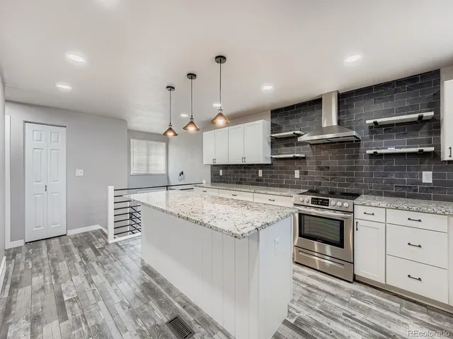 a kitchen with stainless steel appliances granite countertop a stove a sink and a refrigerator