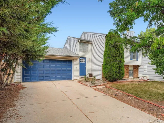a view of house with outdoor space and a tree