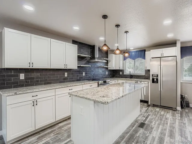 a kitchen with a refrigerator sink and cabinets