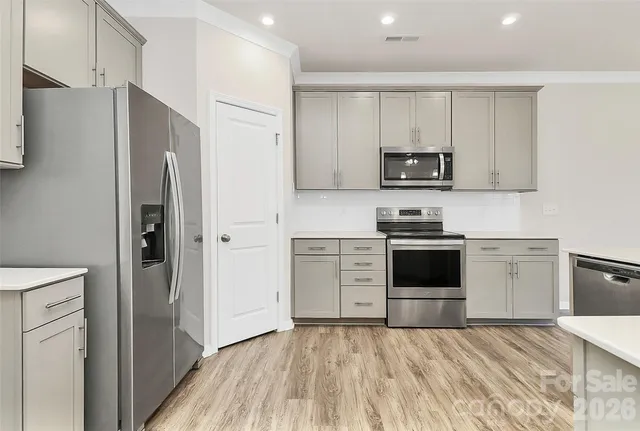 a kitchen with granite countertop a refrigerator stove and sink