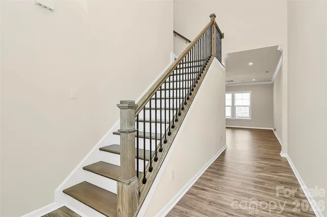 a view of staircase with wooden floor and white walls