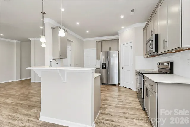 a view of kitchen with sink and refrigerator