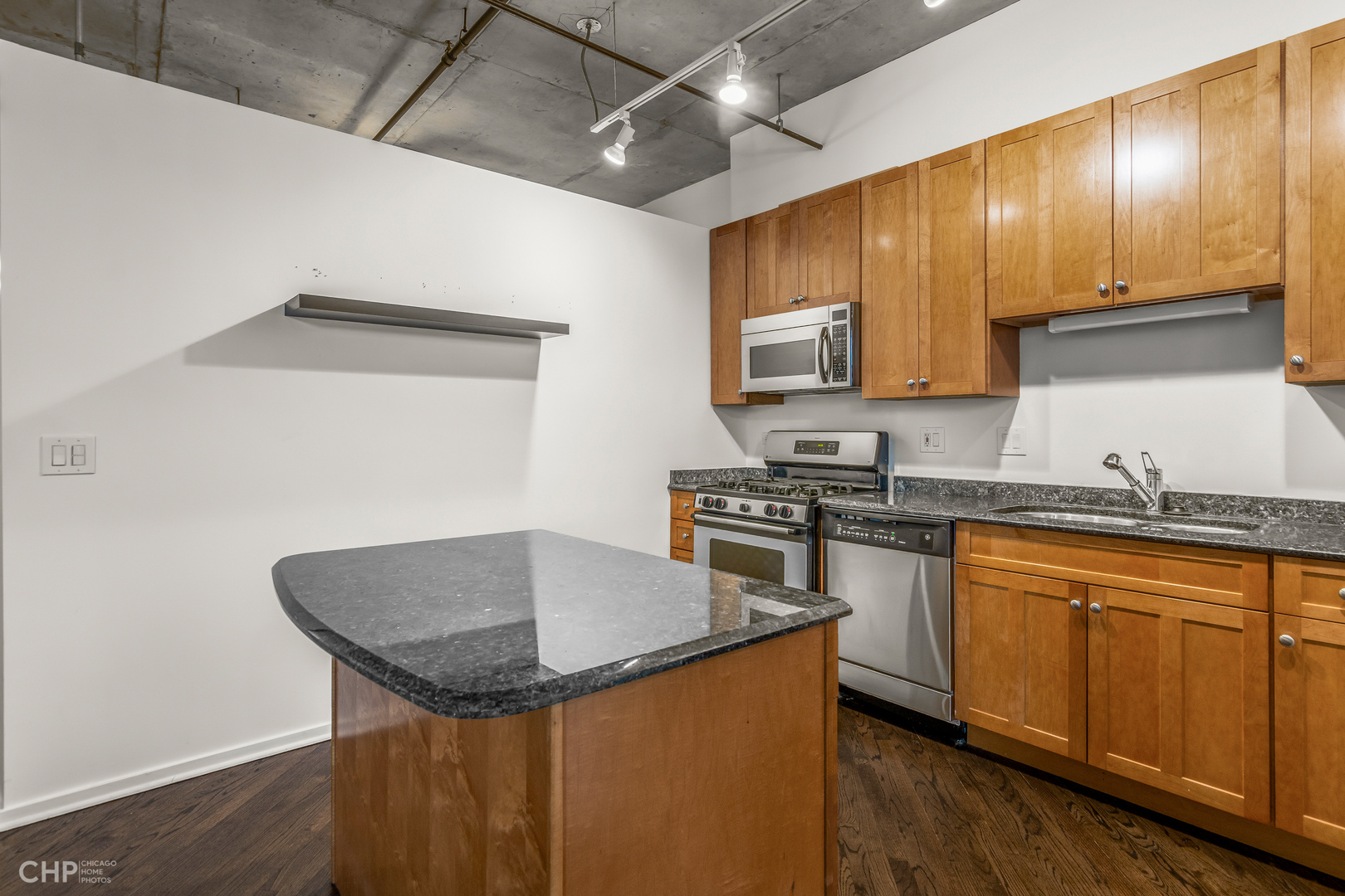 6 South Laflin Street, Unit 721 Chicago, IL 60607 - Photo 8 of 20 a kitchen with granite countertop cabinets stainless steel appliances a sink and wooden floor