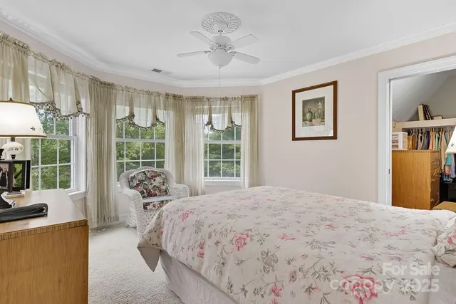 a bedroom with a bed couch and a large window