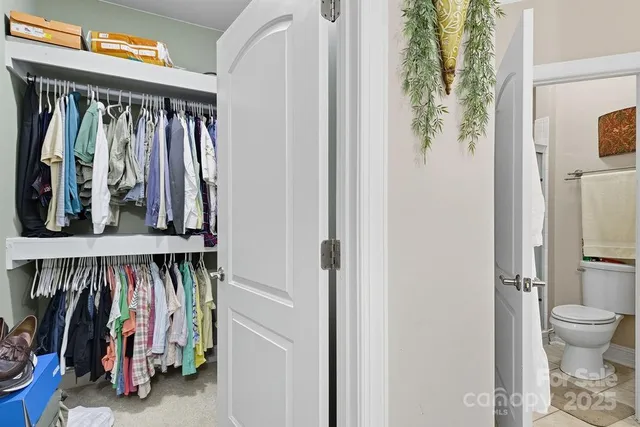 a view of walk in closet with clothes and shoes