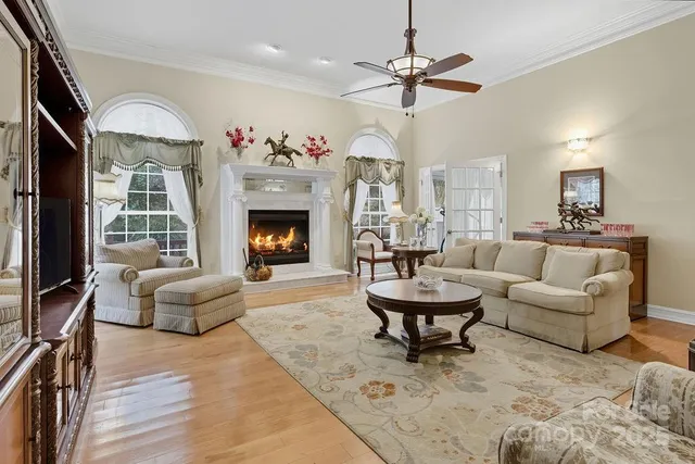 a living room with furniture a fireplace and a large window