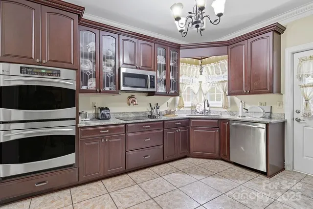 a kitchen with stainless steel appliances granite countertop a stove sink microwave and cabinets