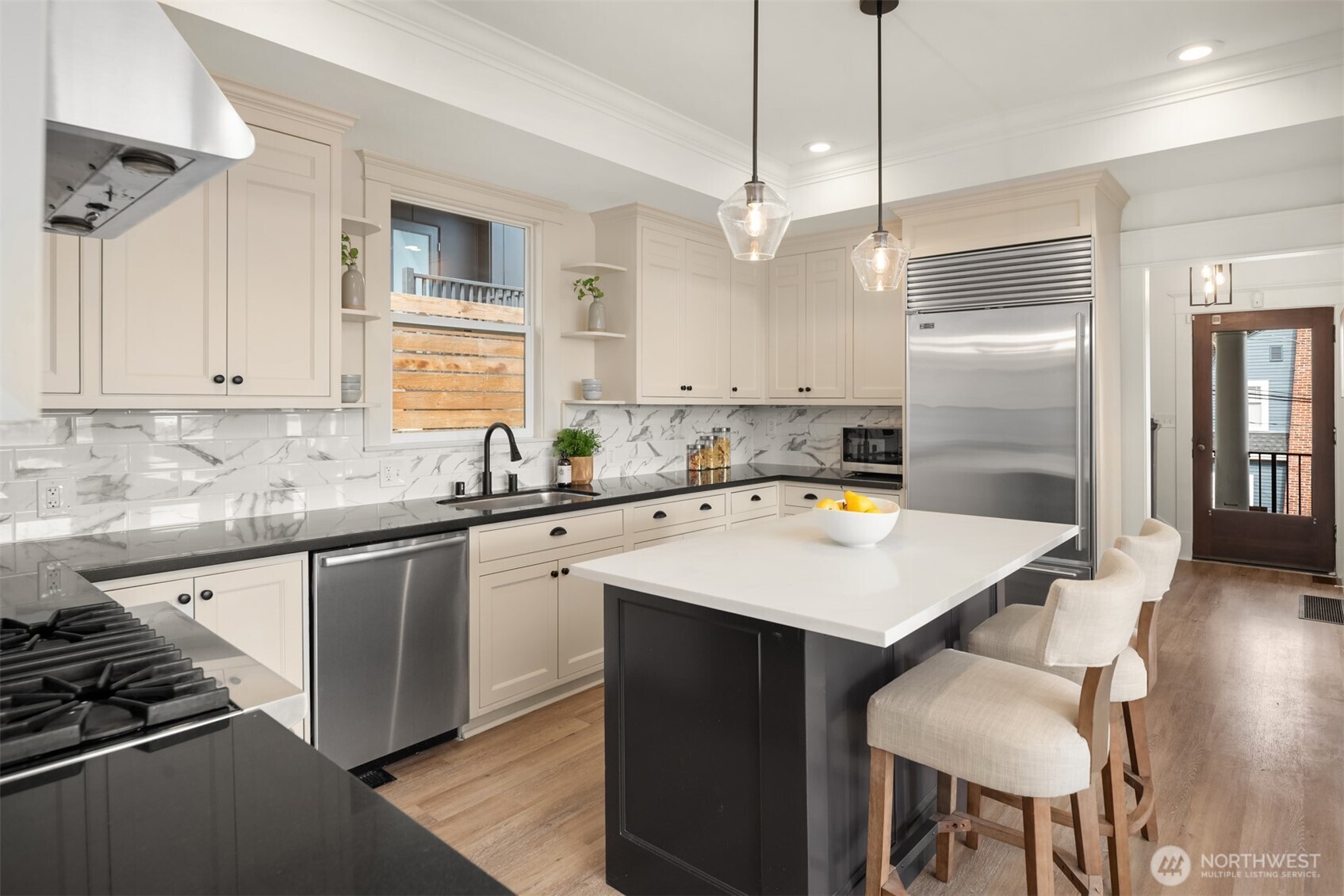 3807 East Jefferson Street Seattle, WA 98122 - Photo 12 of 39 a kitchen with stainless steel appliances a table chairs and white cabinets