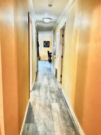 a view of a hallway with wooden floor