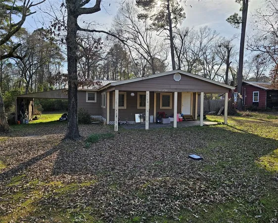 a view of a house with a yard and large tree