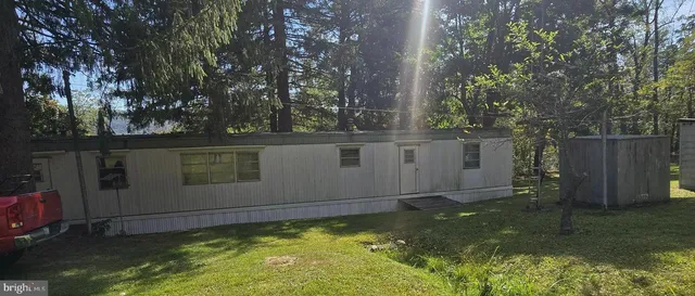 a view of backyard with wooden fence and large trees