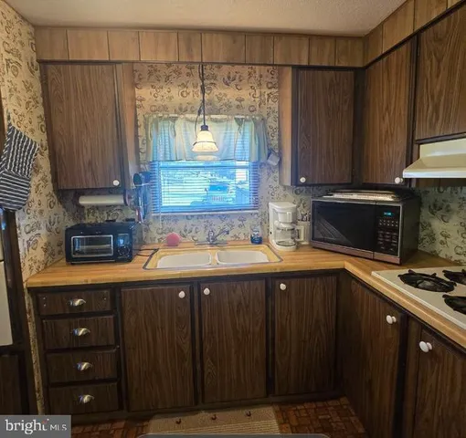 a kitchen with a sink a stove a microwave and cabinets