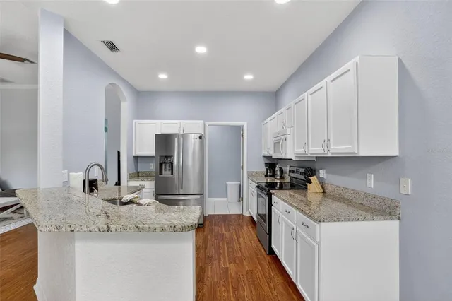 a kitchen with granite countertop a sink and refrigerator