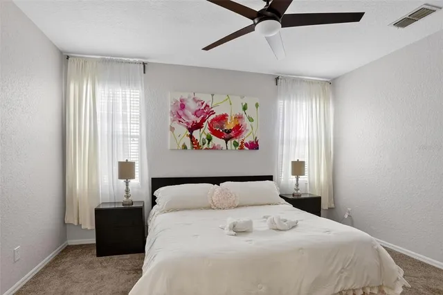 a bedroom with a large bed and a painting on the wall