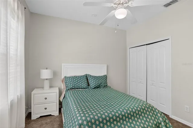 a bedroom with a bed and a lamp on dresser