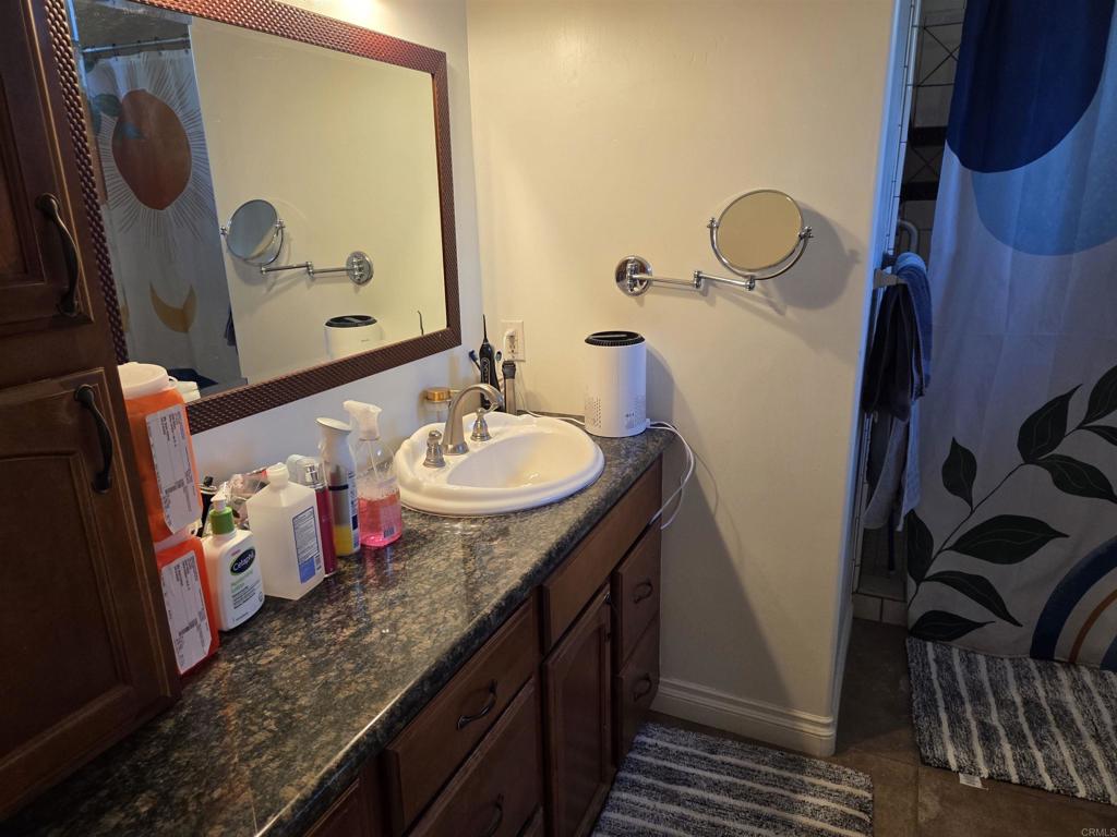 762 Grey Hawk Court Oceanside, CA 92057 - Photo 3 of 14 a bathroom with a granite countertop sink and a mirror