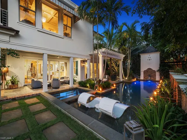 a view of a patio with couches table and chairs potted plants and palm tree