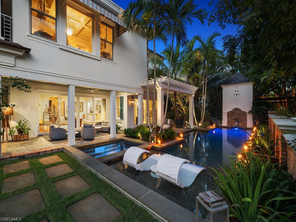 563 3rd Street North Naples, FL 34102 - Photo 14 of 15 a view of a patio with couches table and chairs potted plants and palm tree