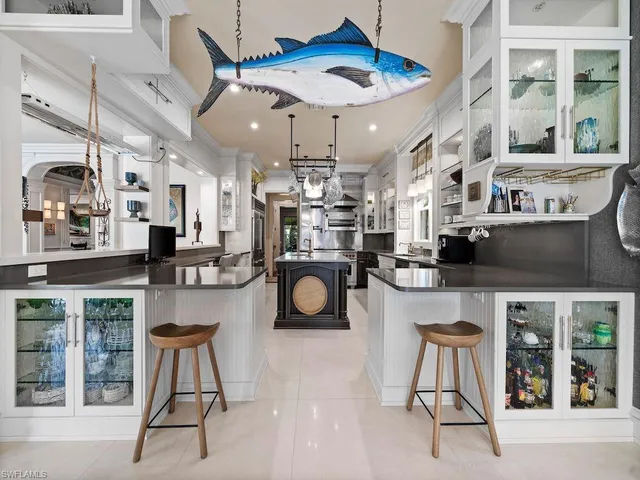 a kitchen with stainless steel appliances granite countertop a dining table chairs cabinets and a stove