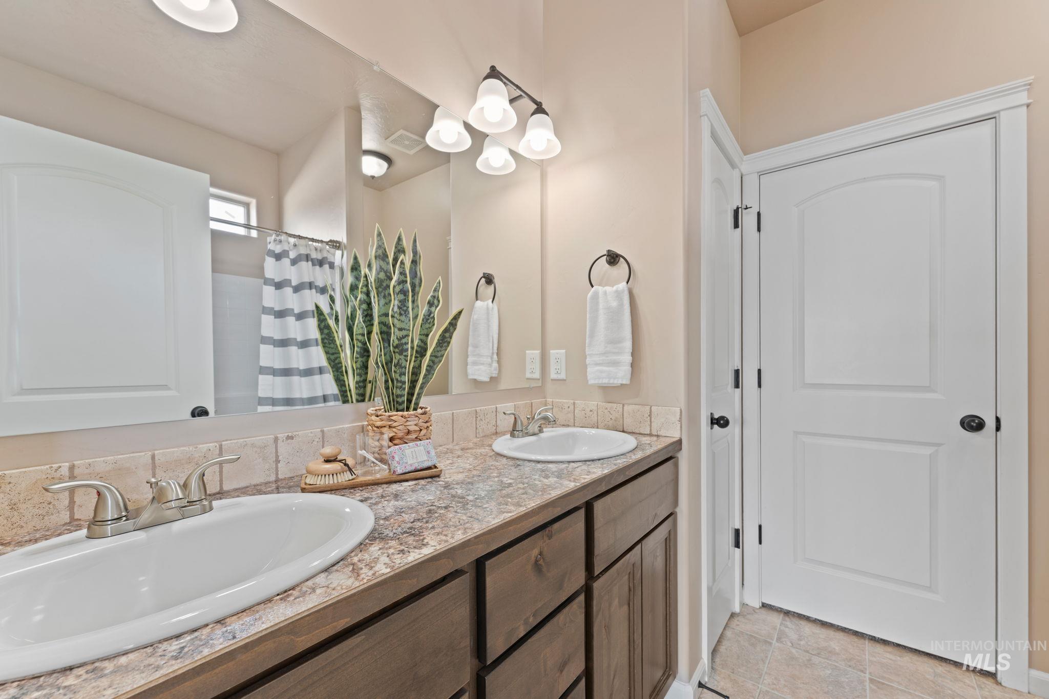 1001 13th Street Rupert, ID 83350 - Photo 17 of 40 Full bath featuring double vanity and a shower with shower curtain