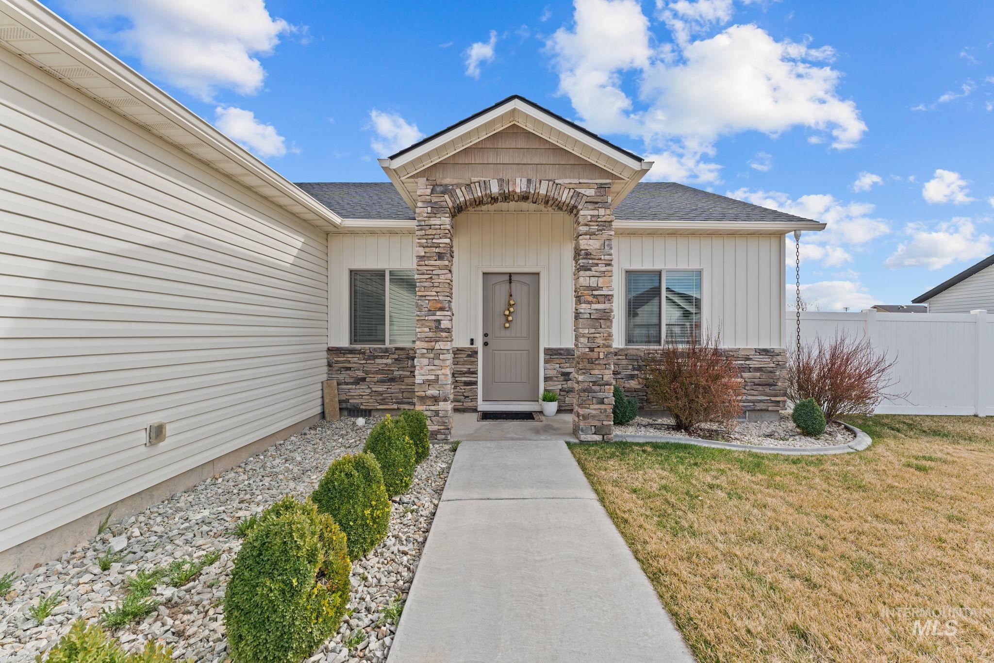 1001 13th Street Rupert, ID 83350 - Photo 2 of 40 Entrance to property featuring stone siding, a shingled roof, and board and batten siding