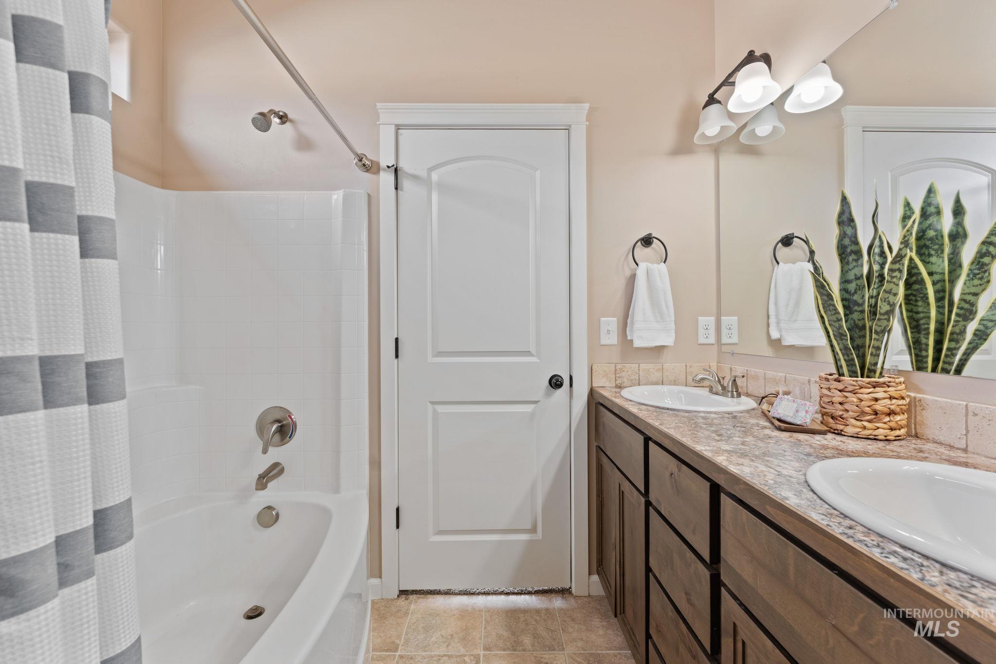 1001 13th Street Rupert, ID 83350 - Photo 20 of 40 Full bathroom featuring double vanity and shower / tub combo with curtain