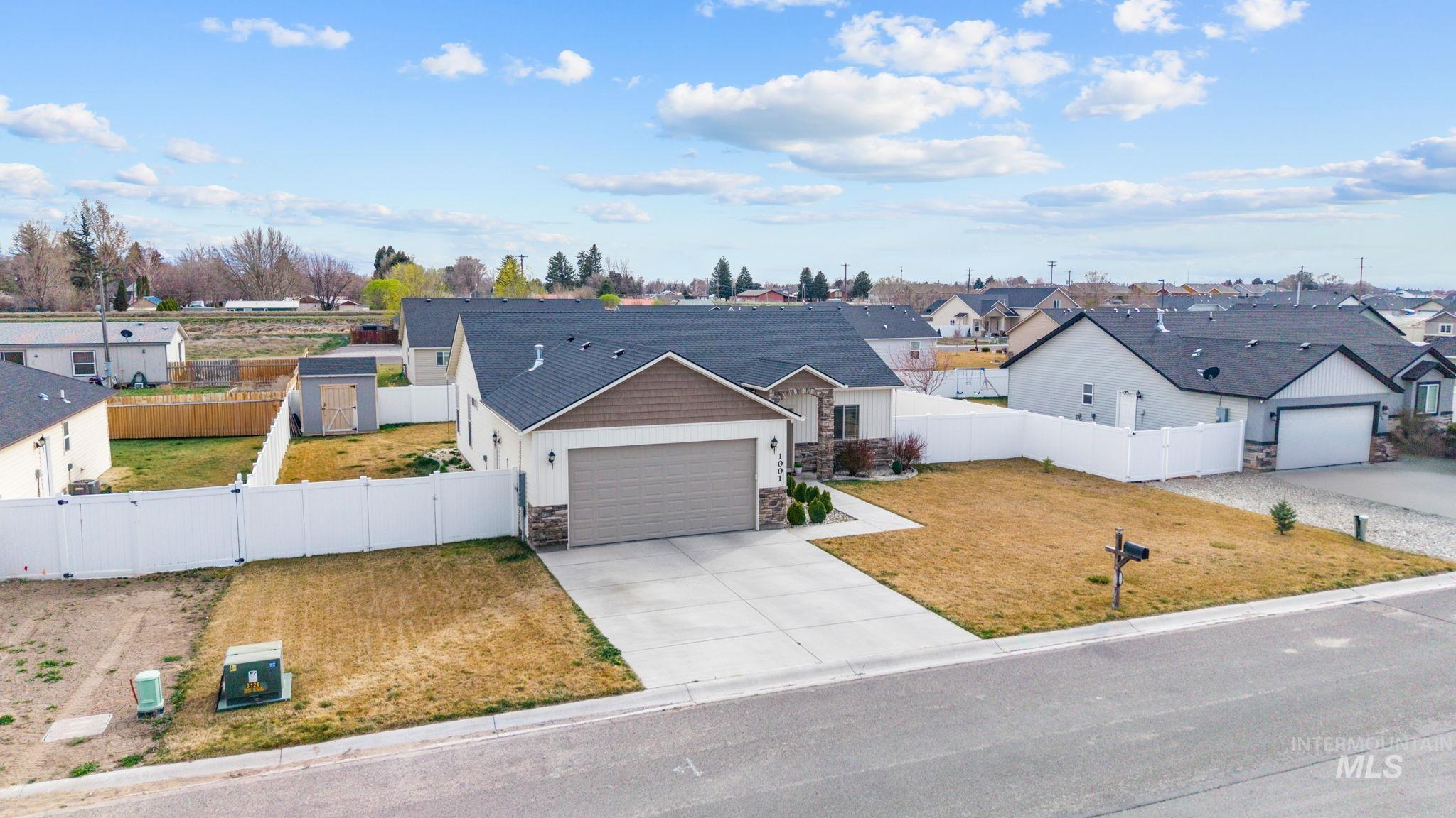 1001 13th Street Rupert, ID 83350 - Photo 34 of 40 View of front of home with stone siding, driveway, a residential view, an attached garage, and a gate