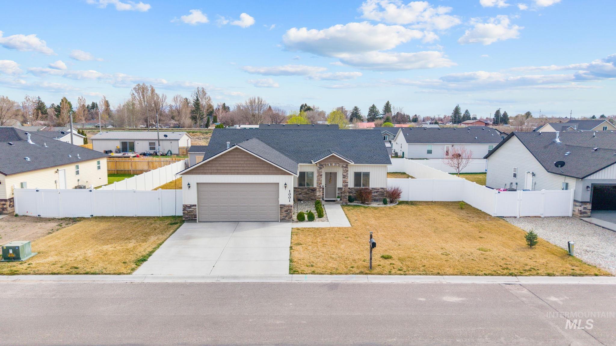 1001 13th Street Rupert, ID 83350 - Photo 35 of 40 View of front of house featuring a residential view, stone siding, concrete driveway, and a garage
