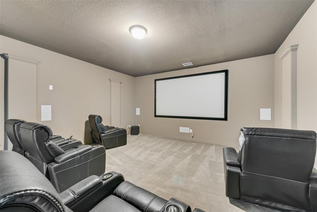 2021 Calisto Way Allen, TX 75013 - Photo 26 of 34 Dedicated media room featuring a large projection screen, wall-mounted speakers, and recessed lighting