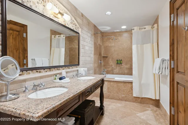 a bathroom with a granite countertop sink a mirror and a shower
