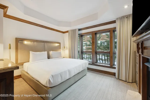 a large bed sitting in a bedroom next to a large window