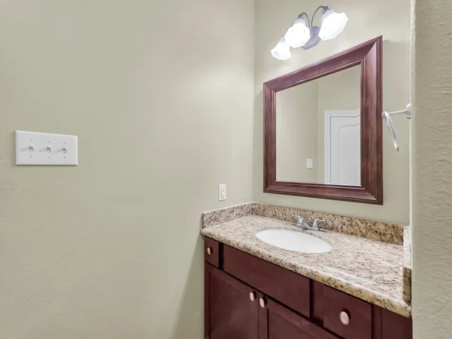 a bathroom with a granite countertop sink a mirror and a shower